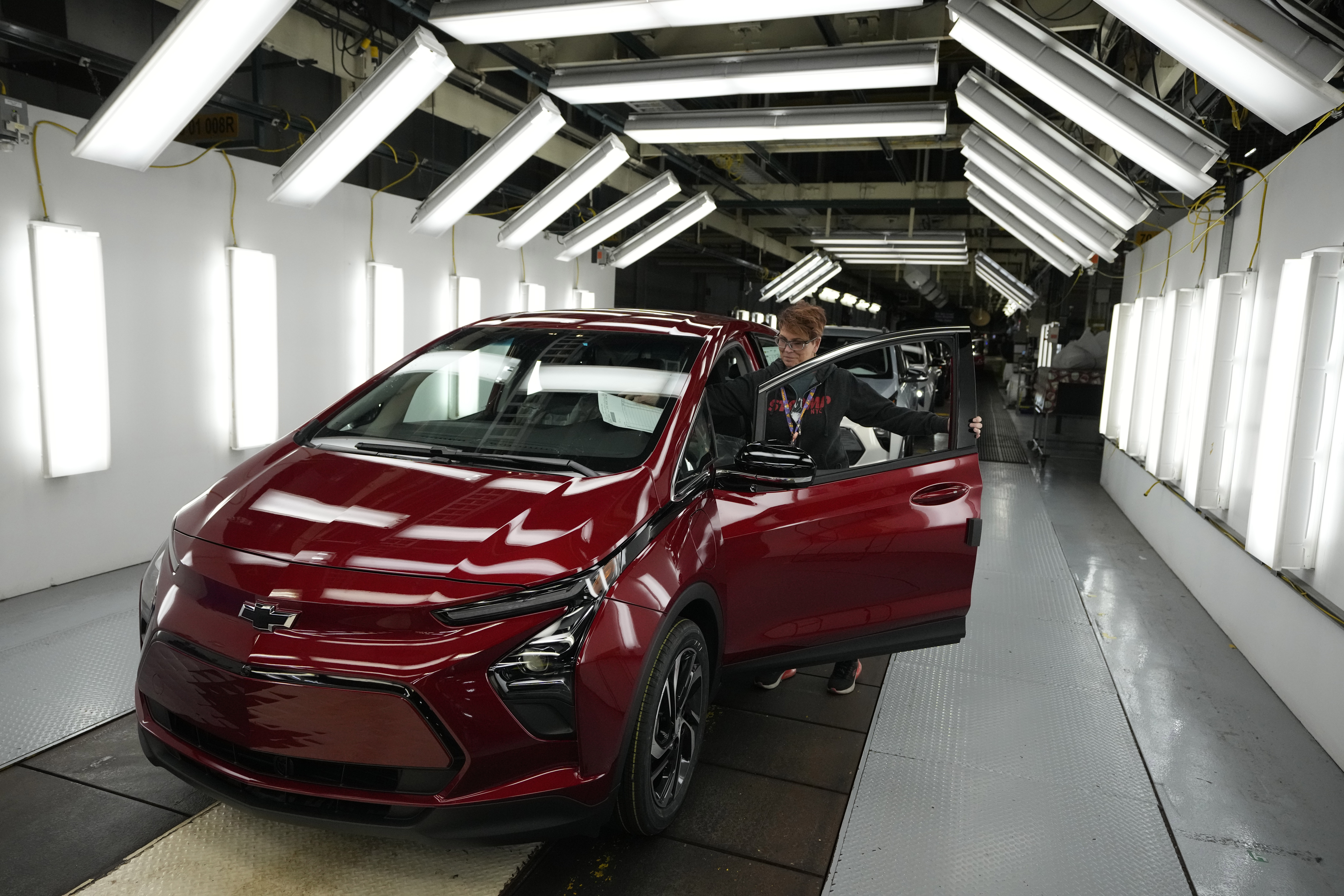 Worker Janice DeBono looks over a 2023 Chevrolet Bolt electric car. 