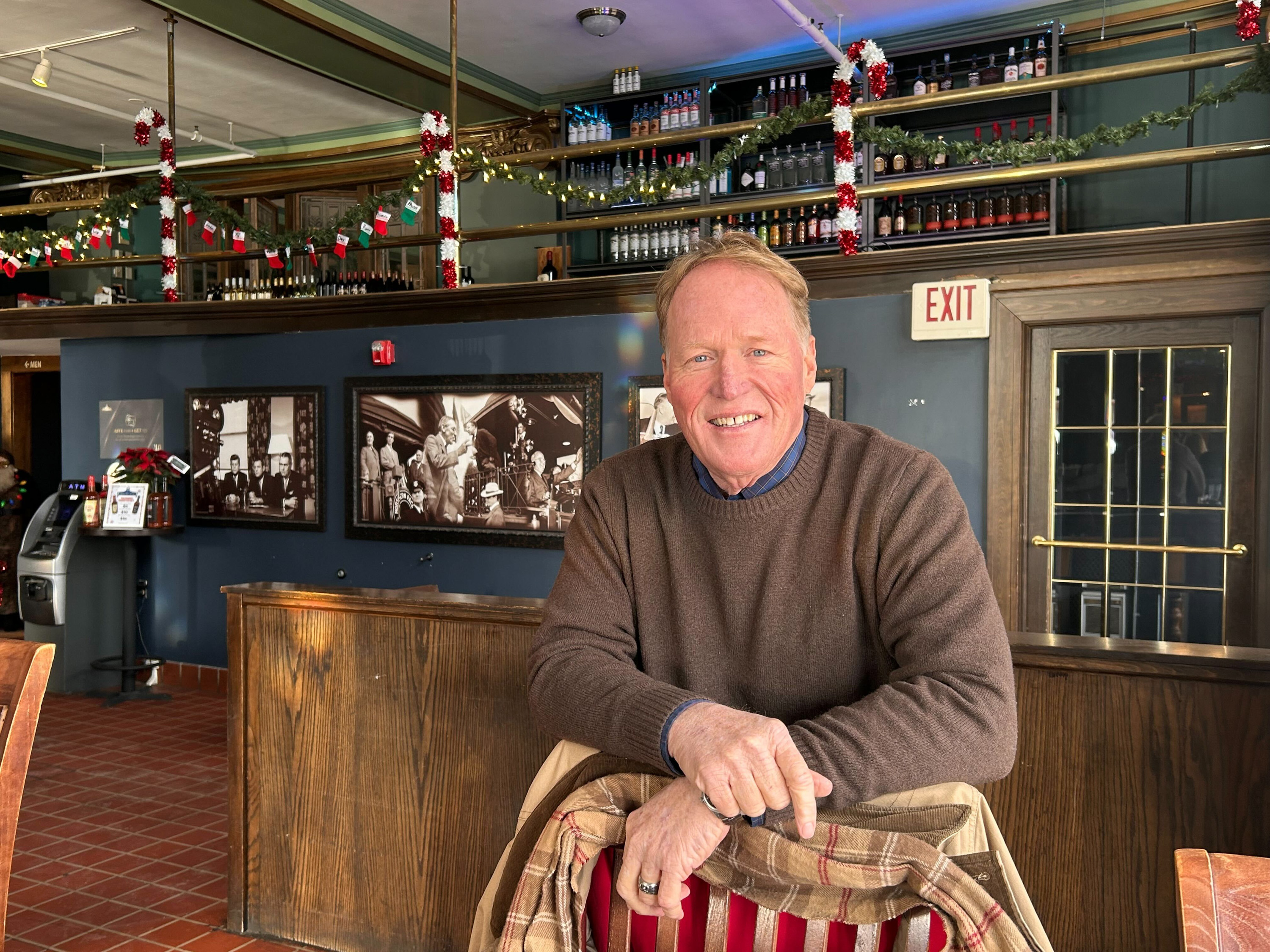 Joel Heitkamp stands behind a chair at the bar.
