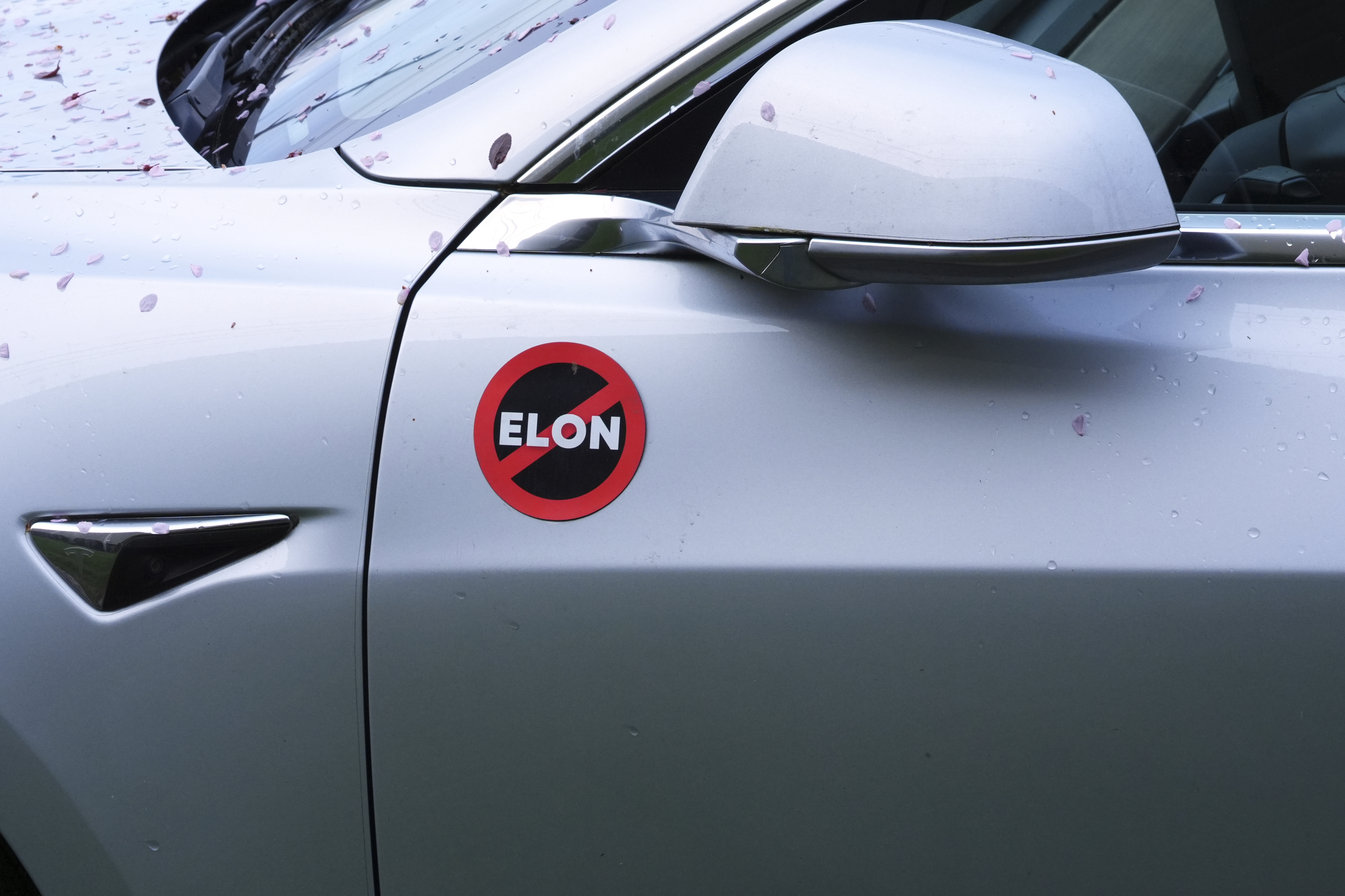 A Tesla vehicle displays an anti-Elon Musk sign.